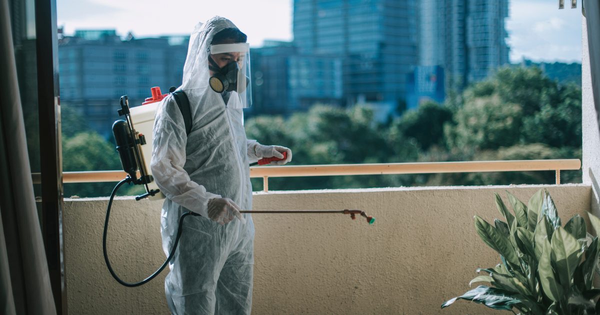 Pest control technician performing treatment on balcony
